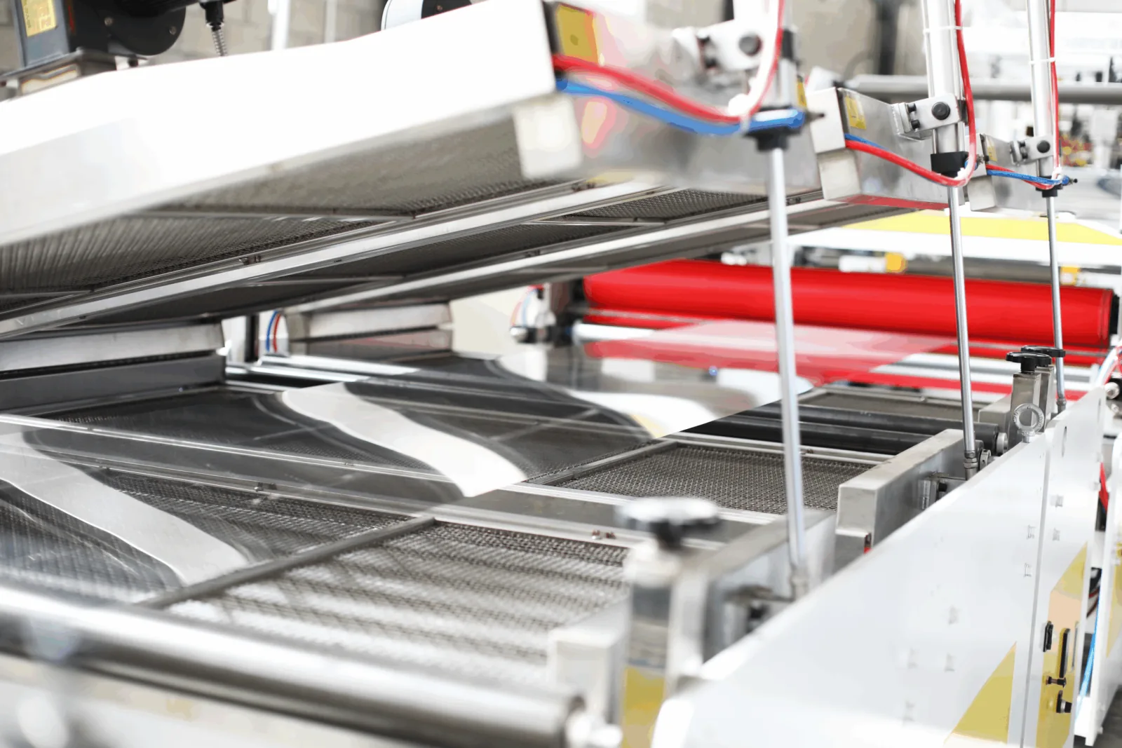 Calender rollers and conveyor carrying finished PET sheet